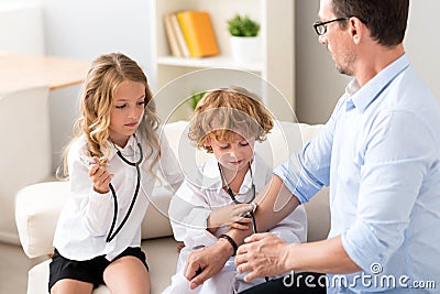 Pensive boy and girl treating father Stock Photo