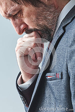 Pensive businessman overburdened with thoughts thinking with hand on chin Stock Photo