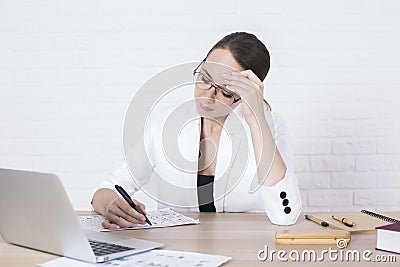 Pensive businesswoman doing paperwork Stock Photo