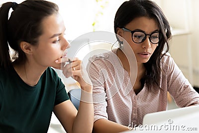 Pensive caucasian and biracial young female students preparing for exams Stock Photo