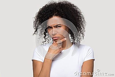 Pensive doubtful African American woman touching chin, thinking Stock Photo