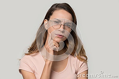 Pensive doubtful woman wearing glasses touching chin, thinking Stock Photo