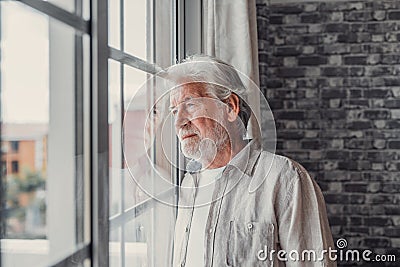Pensive elderly mature senior man in eyeglasses looking in distance out of window, thinking of personal problems. Lost in thoughts Stock Photo