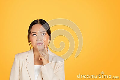 Pensive happy millennial korean lady manager in suit thinks, looking at free space Stock Photo