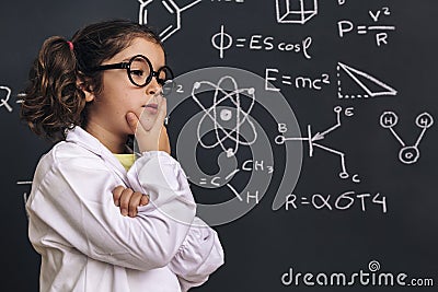 Pensive little girl scientist in lab coat Stock Photo