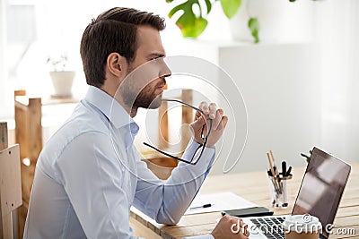 Pensive male employee think of problem solution Stock Photo