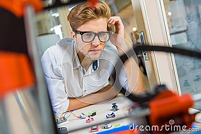 Pensive male engineer studying three dimensional printer Stock Photo