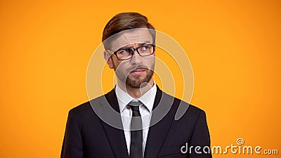 Pensive male thinking about business ideas for start up, orange background Stock Photo