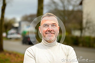 Pensive man looking up with a quiet smile Stock Photo