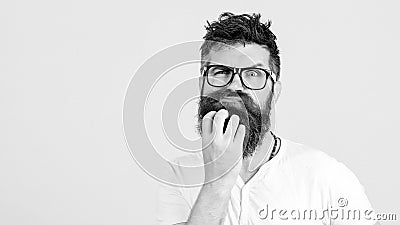 Pensive man touching his beard on white wall. Handsome man in glasses thinks. Emotional bearded guy has a doubt. Human face Stock Photo