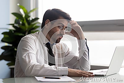 Pensive manager looking at computer screen, making difficult decision. Stock Photo