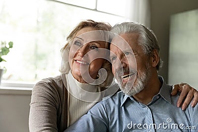 Pensive mature retired family couple looking away and smiling Stock Photo