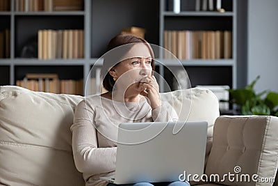 Pensive middle-aged woman look in distance pondering Stock Photo