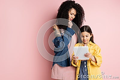 Pensive mother looking at digital tablet Stock Photo