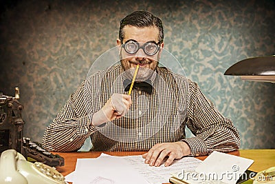 Pensive office employee with a pencil in his mouth looking up in Stock Photo