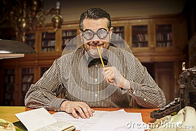 Pensive office employee with a pencil in his mouth looking up Stock Photo