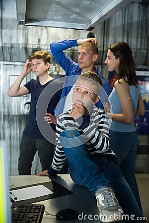 Pensive preteen boy solving riddles in escape room Stock Photo