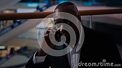 Pensive senior ethnic businessman sad answer call displeased talking mobile phone African American upset frustrated Stock Photo