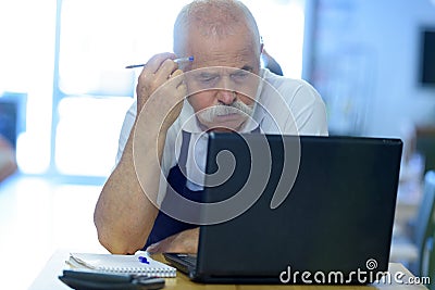 pensive senior man working on laptop Stock Photo