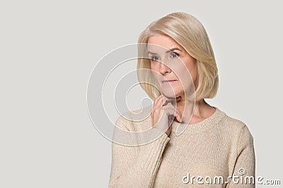 Pensive senior woman isolated on grey background thinking Stock Photo