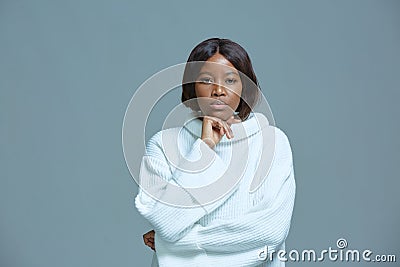 Pensive serious african american young woman staring at camera touch chin lost on thoughts solving problem Stock Photo