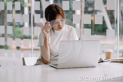 Pensive stressful female employee examining reports while working on complicated project at home Stock Photo