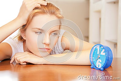 Pensive teenage girl with clock Stock Photo