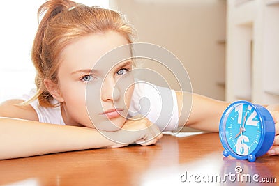 Pensive teenage girl with clock Stock Photo