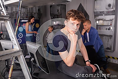 Pensive teenager solving conundrum with family in quest room Stock Photo