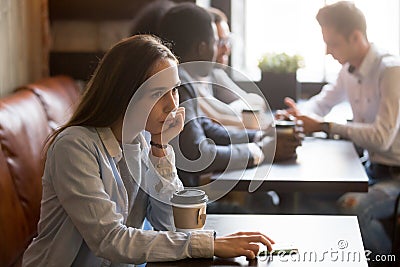 Pensive upset young girl sitting alone at table in cafe Stock Photo