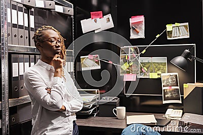 Pensive woman detective thinking about solving crime, rubbing chin Stock Photo