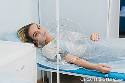 Pensive woman transfused lying in hospital ward Stock Photo