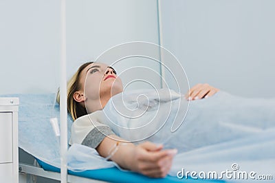 Pensive woman transfused lying in hospital ward Stock Photo