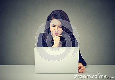 Pensive woman working on laptop computer Stock Photo