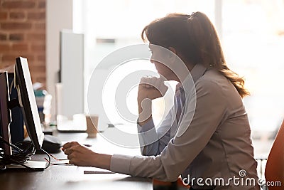 Thoughtful middle aged female employee sitting in workplace feels stressed Stock Photo