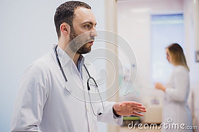 Pensive young doctor in white coat holding diagnosis in hospital, caring doctor concept Stock Photo