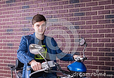 Pensive young motorcyclist waiting on his bike Stock Photo