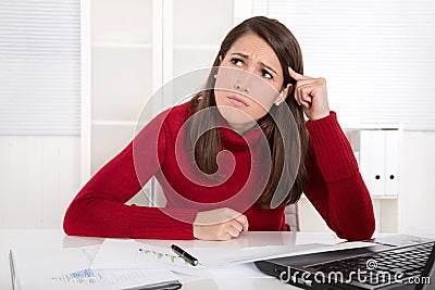 Pensive young trainee at desk - unhappy and bored. Stock Photo
