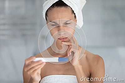 Pensive young woman do ovulation test in home bath Stock Photo
