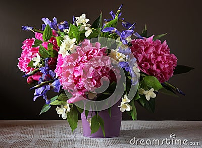 Peonies, irises and Jasmine in a bouquet. Garden flowers in a va Stock Photo