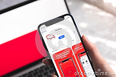 PeoPay mobile banking app in Poland. Hand with smartphone, logo on the screen. Background with national flag Editorial Stock Photo