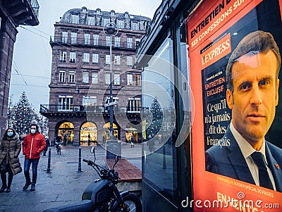 People with anti-Covid-19 masks on French city Street with portrait of French Editorial Stock Photo