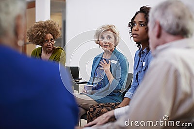 People Attending Self Help Therapy Group Meeting In Community Center Stock Photo