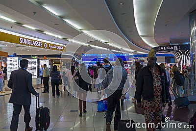 People with baggage walking in Airport duty free area Editorial Stock Photo