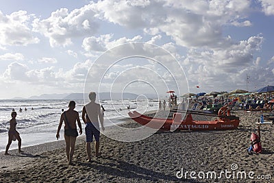 People on the beach shoreline at sunset light in Versilia Editorial Stock Photo