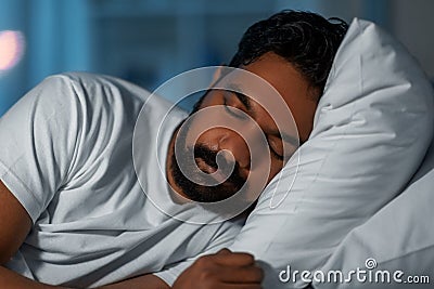 indian man sleeping in bed at home at night Stock Photo