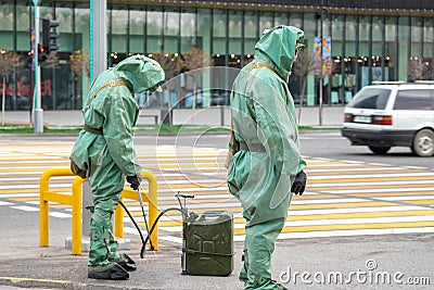 People in bio viral hazard protective suits. Disinfection and decontamination on a public place as a prevention against Editorial Stock Photo