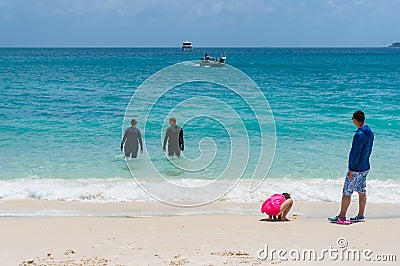 People in black stingersuits in the tropical ocean Editorial Stock Photo