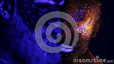 Man and woman face in ultraviolet light. People body under ultraviolet light. People are colored fluorescent powder. Unreal love in ultraviolet light Man and woman face in ultraviolet light. People body under ultraviolet light. People are colored fluorescent powder. Unreal love in ultraviolet light