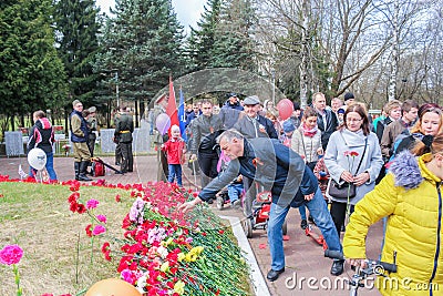 People bringing flowers to the graves of soldiers. Editorial Stock Photo